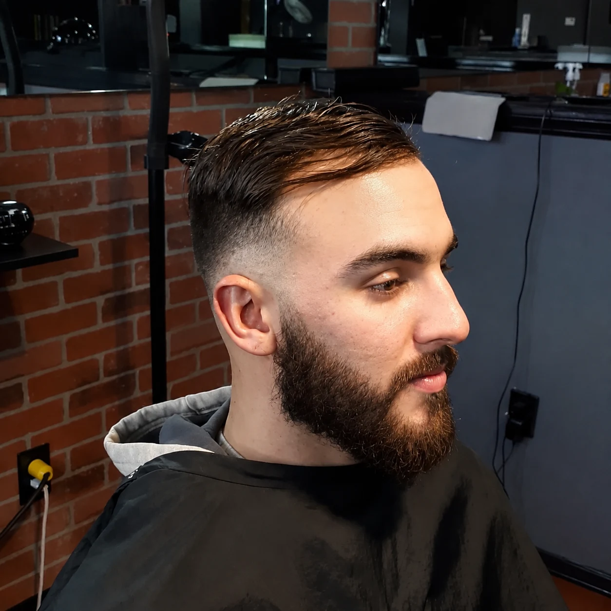 A side-part haircut, fade and shaped beard from Ayesha’s portfolio